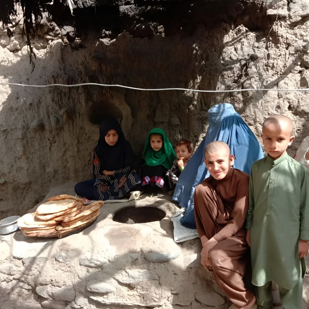 A family beside a clay oven baking bread